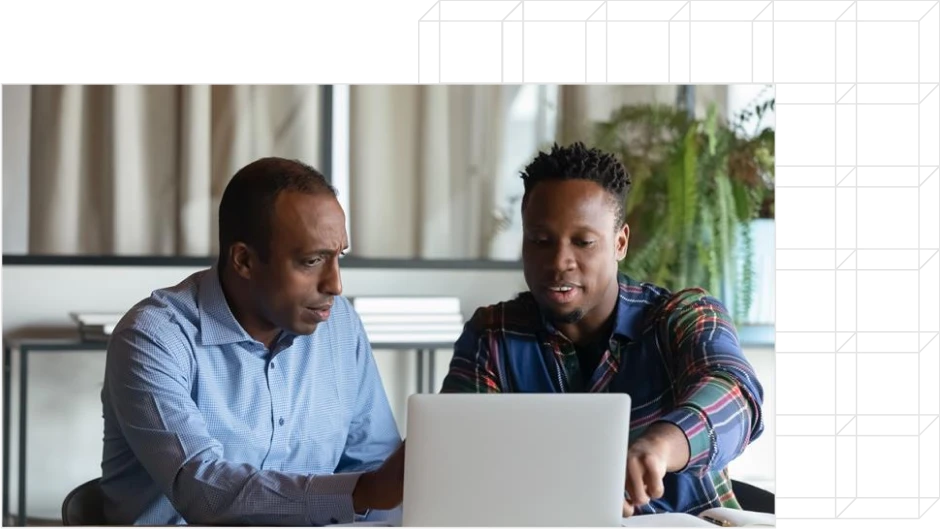 due uomini seduti ad un tavolo discutono davanti ad un laptop due uomini seduti ad un tavolo discutono davanti ad un laptop